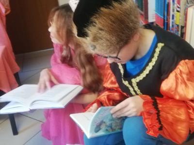 Uczeń i uczennica oglądają książki..