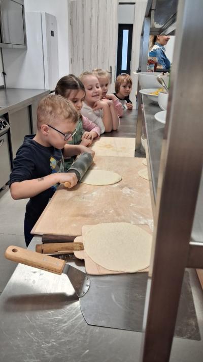 Chłopiec wałkuje ciasto na pizze