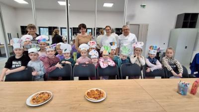 Grupa Pszczółki w czapkach kucharskich pozują do zdjecia.