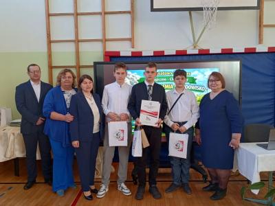 Na zdjęciu uczestnicy konkursu w towarzystwie organizatorów konkursu. Uczniowie trzymająw rękach otrzymane nagrody
