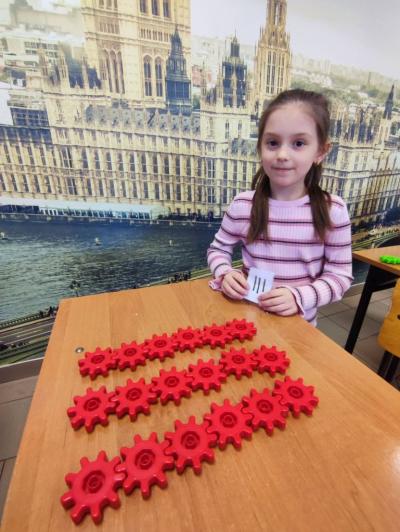 Uczniowie pracujący na klockach Korbo z wykozrystaniem cyfr rzymskich wykorzystanych do budowy planszy zegara