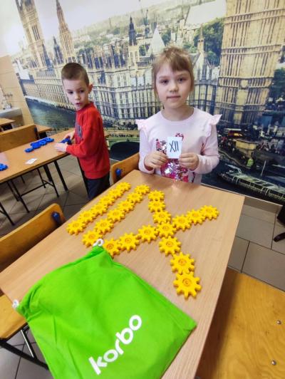 Uczniowie pracujący na klockach Korbo z wykozrystaniem cyfr rzymskich wykorzystanych do budowy planszy zegara