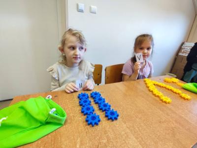 Uczniowie pracujący na klockach Korbo z wykozrystaniem cyfr rzymskich wykorzystanych do budowy planszy zegara