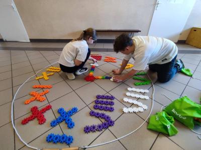 Uczniowie pracujący na klockach Korbo z wykozrystaniem cyfr rzymskich wykorzystanych do budowy planszy zegara