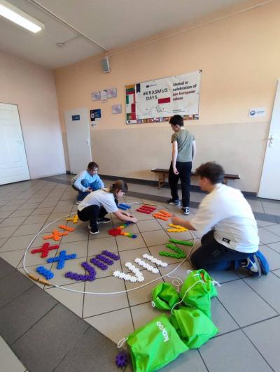 Uczniowie pracujący na klockach Korbo z wykozrystaniem cyfr rzymskich wykorzystanych do budowy planszy zegara