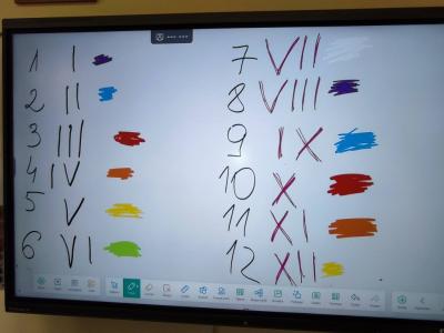Uczniowie pracujący na klockach Korbo z wykozrystaniem cyfr rzymskich wykorzystanych do budowy planszy zegara
