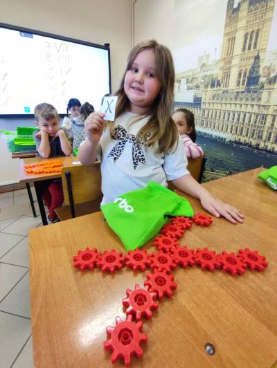 Uczniowie pracujący na klockach Korbo z wykozrystaniem cyfr rzymskich wykorzystanych do budowy planszy zegara