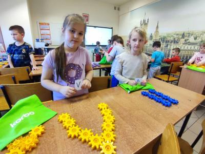 Uczniowie pracujący na klockach Korbo z wykozrystaniem cyfr rzymskich wykorzystanych do budowy planszy zegara