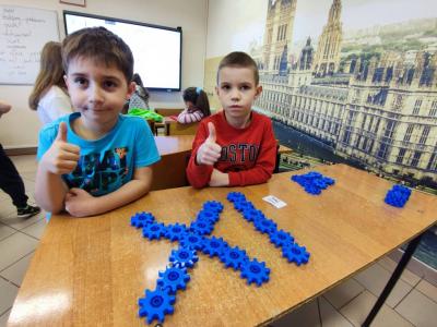 Uczniowie pracujący na klockach Korbo z wykozrystaniem cyfr rzymskich wykorzystanych do budowy planszy zegara