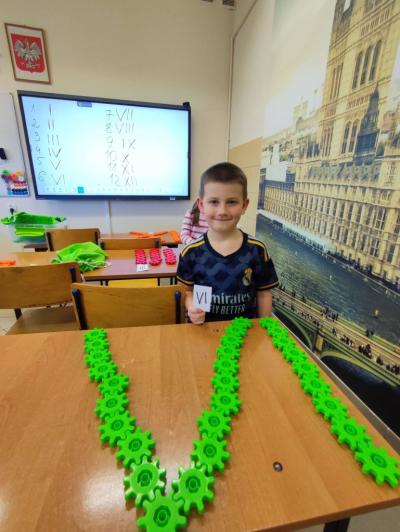 Uczniowie pracujący na klockach Korbo z wykozrystaniem cyfr rzymskich wykorzystanych do budowy planszy zegara