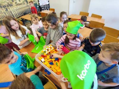 Uczniowie pracujący na klockach Korbo z wykozrystaniem cyfr rzymskich wykorzystanych do budowy planszy zegara