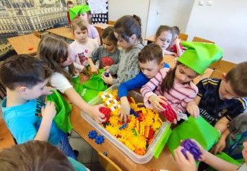 Uczniowie pracujący na klockach Korbo z wykozrystaniem cyfr rzymskich wykorzystanych do budowy planszy zegara