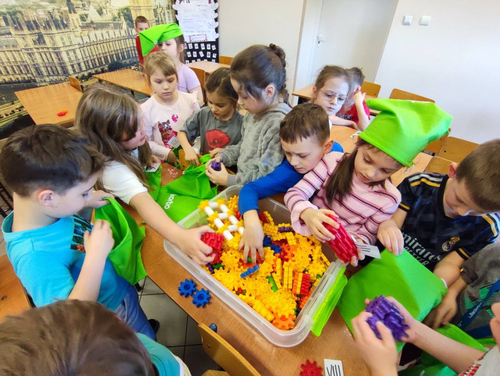 Uczniowie pracujący na klockach Korbo z wykozrystaniem cyfr rzymskich wykorzystanych do budowy planszy zegara