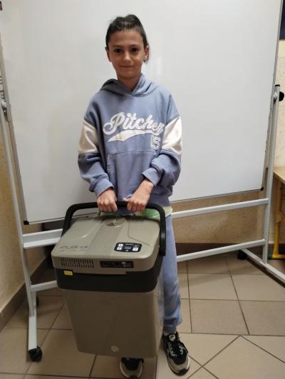 Chłopiec z klasy 5b z lodówką turystyczną zamiast plecaka.