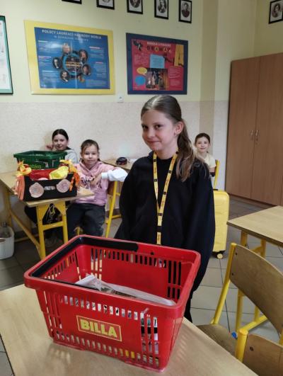 Dziewczynka z klasy 4a, która przyniosła swoje książki w koszyku na zakupy.