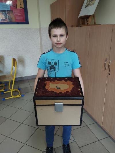 Książki przyniesione przez ucznia klasy 5a w pudełku ozdobionym motywem z Minecrafta.