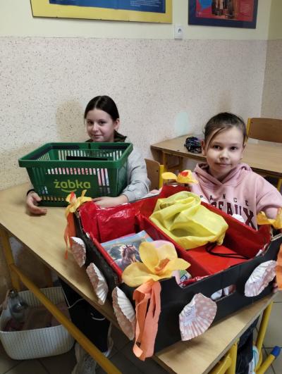 Uczennica klasy 4a z pudełkiem własnoręcznie ozdobionym kwiatami z bibuły zamiast plecaka.