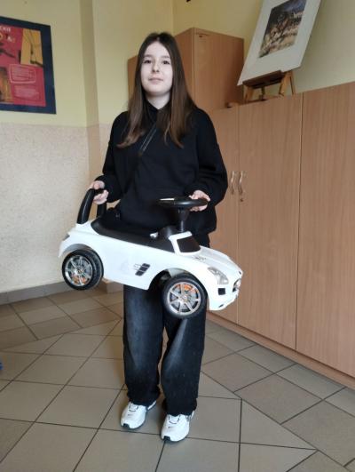 Duży samochód - jeździk dla dzieci zamiast plecaka uczennicy z klasy 6b.