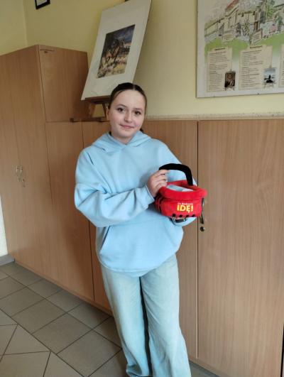 Mały koszyczek - pluszowa zabawka, a w nim przybory szkole.