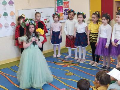 Dziewczynka w stroju wiosny mówi przez mikrofon