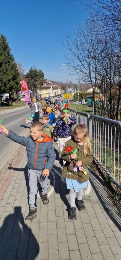 Pochód z kolorowymi kwiatami, bibułami i marzanną