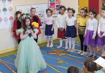 Dziewczynka w stroju wiosny mówi przez mikrofon