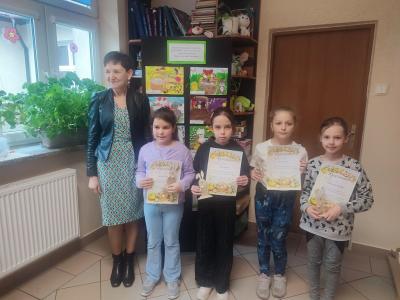 Pani dyrektor z czterema dziewczynkami trzymajacymi dypolmy pozują do zdjęcia