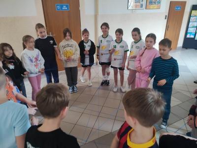 Uczniowie tworzą nić przyjaźni z włóczki.