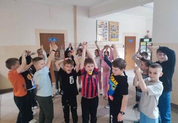 Uczniowie tworzą nić przyjaźni z włóczki.