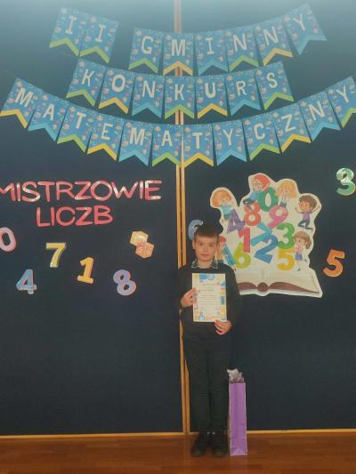 Uczeń biorący udział w konkursie pozuje do zdjęcia