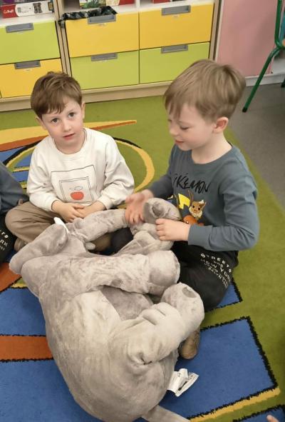Dwoje dzieci siedzące na dywanie ze słoniem z projektu Dwujęzyczny przedszkolak
