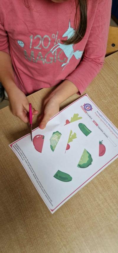 Dziecko wycina kartę pracy z projektu Dwujęzyczny przedszkolak