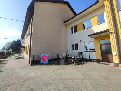 Zdjęcie szkoły i wejscia do przedszkola z plakatem Dwujęzyczny przedszkolak.