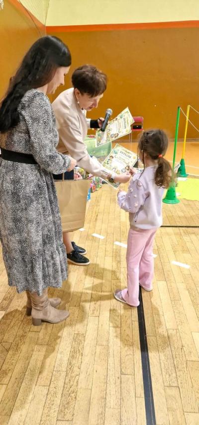 Dziewczynka odbiera nagrodę za wyróżnienie
