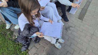grupa uczniów w skupieniu kreśli kolejne elementy szkicu