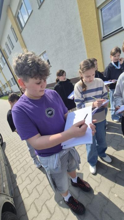 grupa uczniów w skupieniu kreśli kolejne elementy szkicu