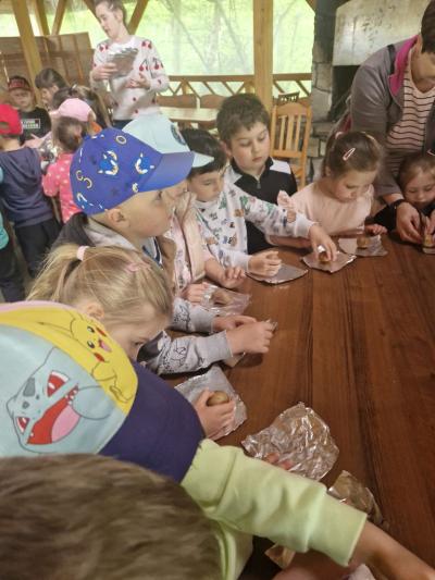 Dzieci zawijają ziemniki w folię spożywczą