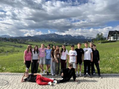 klasa 6b oraz 2 nauczycielki stoją na tarasie hotelu w Murzasichle, widok na Tatry