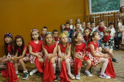 Dzieci siedzą przy scenie, rodzice na widowni przed sceną ogladają występy dzieci.