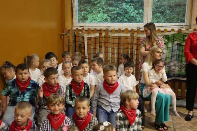 Dzieci siedzą przy scenie, rodzice na widowni przed sceną ogladają występy dzieci.