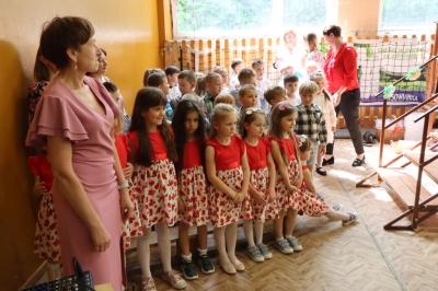 Dzieci w odświetnych strojch siedzące przy scenie