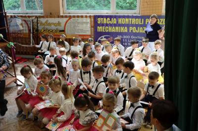 Dzieci w odświetnych strojch siedzące przy scenie