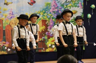 Przedszkolaki w kolorowych strojach występują na scenie z okazji Święta Rodziny
