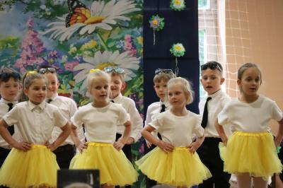 Przedszkolaki w kolorowych strojach występują na scenie z okazji Święta Rodziny