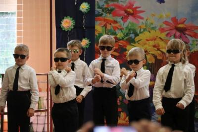 Przedszkolaki w kolorowych strojach występują na scenie z okazji Święta Rodziny
