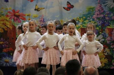 Przedszkolaki w kolorowych strojach występują na scenie z okazji Święta Rodziny