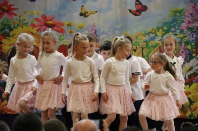Przedszkolaki w kolorowych strojach występują na scenie z okazji Święta Rodziny