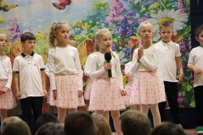 Przedszkolaki w kolorowych strojach występują na scenie z okazji Święta Rodziny
