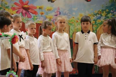 Przedszkolaki w kolorowych strojach występują na scenie z okazji Święta Rodziny