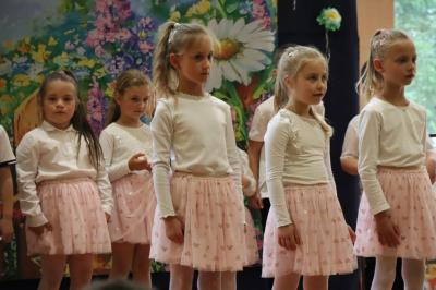Przedszkolaki w kolorowych strojach występują na scenie z okazji Święta Rodziny